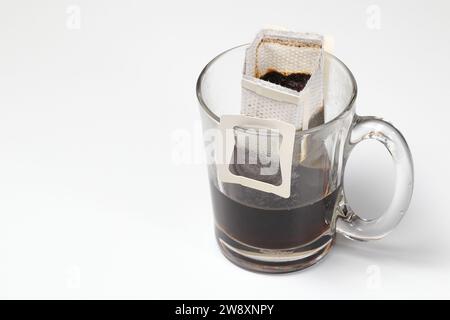 Infuser le café moulu à l'aide du filtre instantané de type papier, égoutter le sac de café dans une tasse, infuser le café dans un verre avec un sac d'égouttement. Banque D'Images