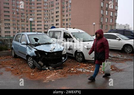 Kiev, Ukraine. 22 décembre 2023. Une femme passe devant des voitures endommagées à la suite d'une attaque de drone russe à Kiev. L'armée russe a attaqué l'Ukraine avec des drones d'attaque Shahed. L’armée ukrainienne a affirmé avoir détruit 24 drones russes sur 28. (Photo de Sergei Chuzavkov/SOPA Images/Sipa USA) crédit : SIPA USA/Alamy Live News Banque D'Images