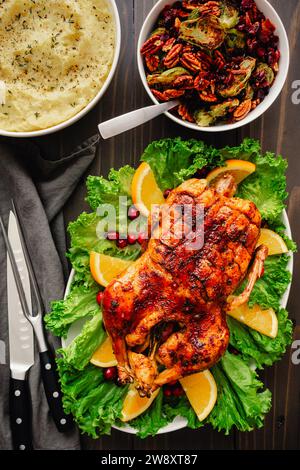 Canard rôti de Noël glacé avec choux de Bruxelles et purée de pommes de terre : dîner de Noël avec canard glacé sur un plateau garni de plats d'accompagnement Banque D'Images