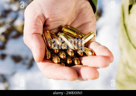 Le combattant tient une poignée de balles dans sa paume pour des armes. Supports mixtes Banque D'Images