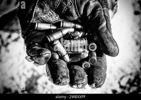 Le combattant tient une poignée de balles dans sa paume pour des armes. Supports mixtes Banque D'Images