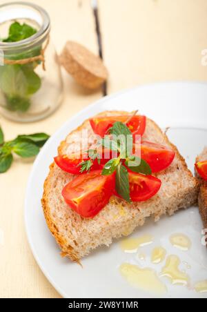 Bruschetta italienne à la tomate avec des feuilles de thym et de menthe, Photographie alimentaire, Photographie alimentaire Banque D'Images