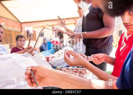 mâle préparant barbecue sur poêle en pierre pendant le temps de fête Banque D'Images