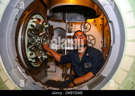 Océan Atlantique, en mer. 11 décembre 2023. Machinin's Mate de 3rd Class Thomas Patrick effectue la maintenance d'une trappe à bord du sous-marin d'attaque de classe Virginia USS Delaware (SSN 791), 11 décembre 2023. Le Delaware est actuellement en cours dans la zone d'opérations de la 4e flotte des États-Unis. Crédit : U.S. Navy/ZUMA Press Wire/ZUMAPRESS.com/Alamy Live News Banque D'Images