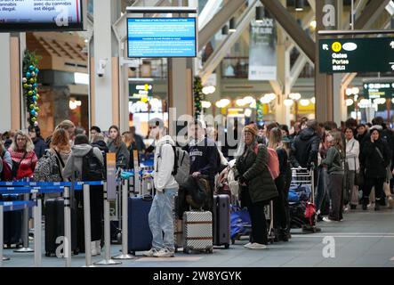 Richmond, Canada. 22 décembre 2023. Les passagers attendent de s'enregistrer à l'aéroport international de Vancouver à Richmond, Colombie-Britannique, Canada, le 22 décembre 2023. Le vendredi a été marqué comme le jour de voyage le plus achalandé de la saison des fêtes, selon l’Administration de l’aéroport international de Vancouver. Crédit : Liang Sen/Xinhua/Alamy Live News Banque D'Images