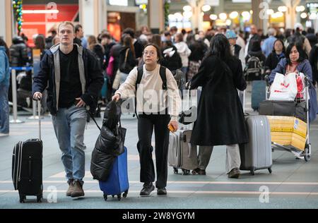 Richmond, Canada. 22 décembre 2023. Des voyageurs sont vus à l'aéroport international de Vancouver à Richmond, Colombie-Britannique, Canada, le 22 décembre 2023. Le vendredi a été marqué comme le jour de voyage le plus achalandé de la saison des fêtes, selon l’Administration de l’aéroport international de Vancouver. Crédit : Liang Sen/Xinhua/Alamy Live News Banque D'Images