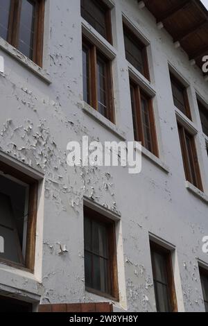 semble usé des fenêtres du bâtiment avec de la peinture murale qui s'écaille Banque D'Images