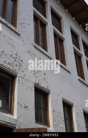 semble usé des fenêtres du bâtiment avec de la peinture murale qui s'écaille Banque D'Images