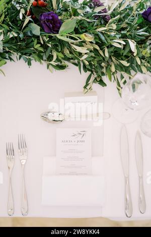 Invitation se trouve sur la table de set près des couverts devant le bouquet Banque D'Images