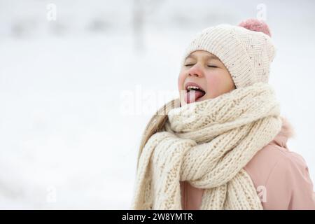 Mignon petite fille s'amusant dans le parc enneigé le jour d'hiver, espace pour le texte Banque D'Images