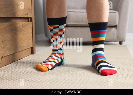 Homme dans différentes chaussettes élégantes à l'intérieur, gros plan Banque D'Images