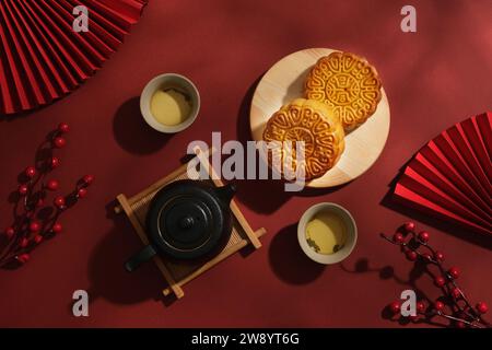 Mise en page publicitaire pour les produits de gâteau de lune sur un fond rouge. Gâteaux de lune sur plateau en bois décoré avec un ensemble de thé et quelques jolies. Moyen-Autum chinois Banque D'Images