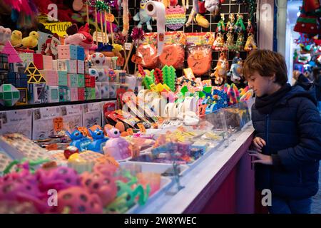 Madrid, Espagne. 22 décembre 2023. Un garçon regarde des jouets à une foire de Noël à Madrid, en Espagne, le 22 décembre 2023. Crédit : Meng Dingbo/Xinhua/Alamy Live News Banque D'Images