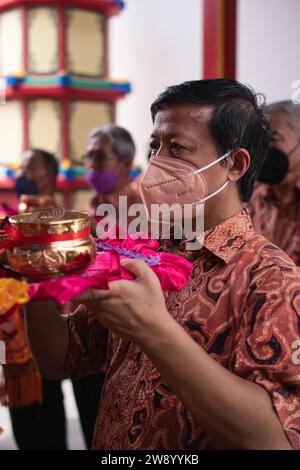 Bandung, Indonésie - 8 janvier 2022 : le touriste apporte les offrandes pour les moines tout en priant le dieu ensemble au temple de Bouddha à l'intérieur du Banque D'Images