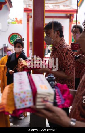 Bandung, Indonésie - 8 janvier 2022 : le touriste apporte les offrandes pour les moines tout en priant le dieu ensemble au temple de Bouddha à l'intérieur du Banque D'Images