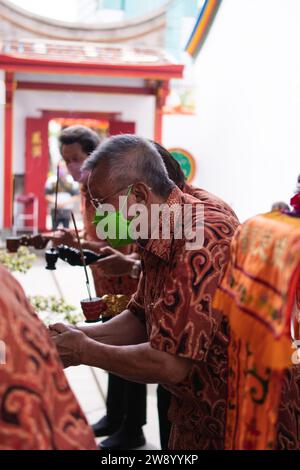 Bandung, Indonésie - 8 janvier 2022 : le touriste apporte les offrandes pour les moines tout en priant le dieu ensemble au temple de Bouddha à l'intérieur du Banque D'Images