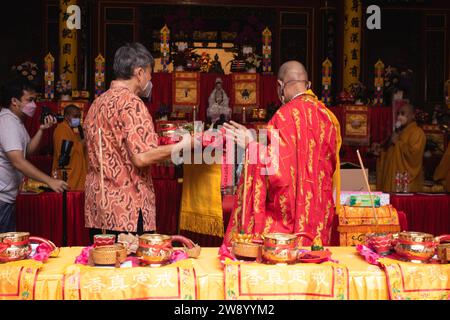 Bandung, Indonésie - 8 janvier 2022 : le touriste apporte les offrandes pour les moines tout en priant le dieu ensemble au temple de Bouddha à l'intérieur du Banque D'Images