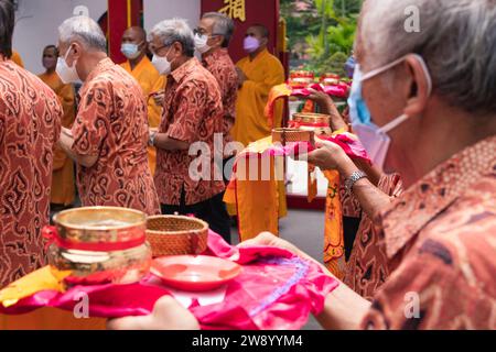 Bandung, Indonésie - 8 janvier 2022 : le touriste apporte les offrandes pour les moines tout en priant le dieu ensemble au temple de Bouddha à l'intérieur du Banque D'Images