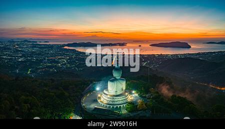 Vue aérienne paysage lumière jaune à l'horizon au lever du soleil devant Phuket Big Buddha le soleil doré brille à travers les nuages. La beauté du statut Banque D'Images