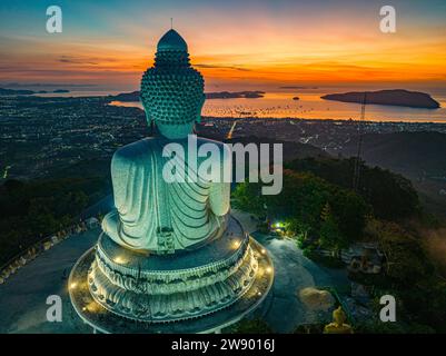 Vue aérienne paysage lumière jaune à l'horizon au lever du soleil devant Phuket Big Buddha le soleil doré brille à travers les nuages. La beauté du statut Banque D'Images