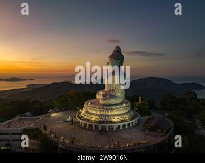 Vue aérienne paysage lumière jaune à l'horizon au lever du soleil devant Phuket Big Buddha le soleil doré brille à travers les nuages. La beauté du statut Banque D'Images