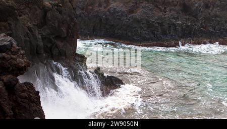 Vue panoramique de Los Hervideros. Côte sud-ouest, côte volcanique accidentée, surf fort, grottes marines, collines de lave rouge. Lanzarote, Îles Canaries, Espagne Banque D'Images