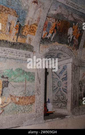 Des fresques peintes dans les années 1500 représentent des scènes de la vie du légendaire héros suisse et symbole national de la liberté, Guillaume (Wilhelm) Tell. Les fresques se trouvent à l’intérieur d’une chapelle construite en 1552 sur le site réputé de la maison natale de Guillaume Tell à Bürglen, canton d’Uri, Suisse. Elles ont été découvertes en 1949 sous des peintures murales postérieures et sont les premières fresques connues représentant William Tell, qui peut être identifié dans cette image dans la fresque en haut à gauche par ses vêtements distinctifs orange et noirs de la couleur du parti. Banque D'Images