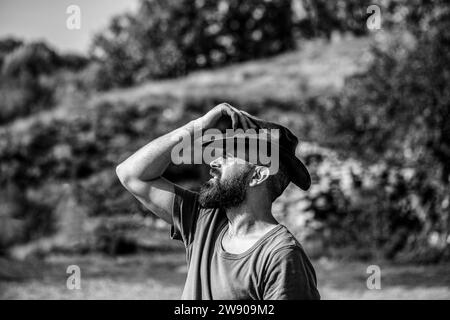 Portrait d'un jeune homme portant un chapeau de cow-boy. Cowboys en chapeau. Beau macho barbu. Homme non rasé cow-boys. Noir et blanc Banque D'Images