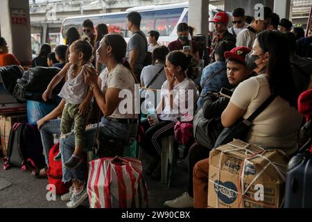 Quezon City, Metro Manila, Philippines. 23 décembre 2023. Les passagers font la queue en attendant de monter à bord de leur bus désigné à un terminal de bus à Quezon City, aux Philippines. 23 décembre 2023. Des millions de Philippins devraient affluer vers les bus terminalsÂ et les ports pour se rendre à Manille et en revenir pour célébrer la saison des fêtes. (Image de crédit : © Basilio Sepe/ZUMA Press Wire) USAGE ÉDITORIAL SEULEMENT! Non destiné à UN USAGE commercial ! Banque D'Images