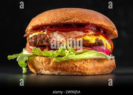 Délicieux hamburger boeuf et bacon, sandwich, restauration rapide, nourriture délicieuse, gros plan sur fond noir. Banque D'Images