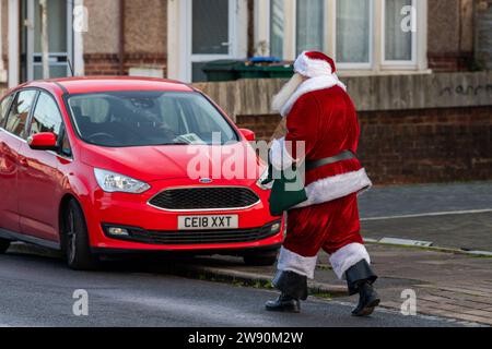 Radford, Coventry, Royaume-Uni. 23 décembre 2023. Le Père Noël a été vu rendre visite à des enfants dans un lotissement à Radford ce matin dans ce qui était une visite impromptue. Le Père Noël dansait dans la rue après avoir rendu visite à des enfants. Crédit : AG News/Alamy Live News Banque D'Images