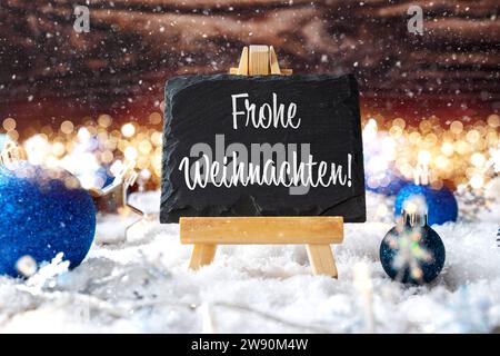 23 décembre 2023 : Joyeux Noël lettres de voeux sur une planche d'ardoise dans la neige avec lumières de Noël et boules de Noël bleu PHOTOMONTAGE *** Frohe Weihnachten Gruß Schriftzug auf einer Schiefertafel in Schnee mit Weihnachtsbeleuchtung und blauen Christbaumkugeln FOTONTAGE Banque D'Images