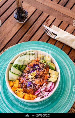 une image portrait d'un bol de saumon fraîchement fait avec des couverts sur une table en bois Banque D'Images