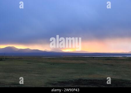 Coucher de soleil vue sur le lac Songkol, la steppe et les montagnes environnantes au Kirghizistan Banque D'Images