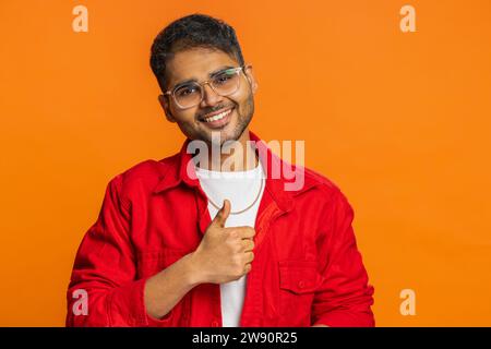 J'aime. L'homme indien soulève les pouces vers le haut est d'accord avec quelque chose ou donne une réponse positive recommande la publicité aime la rétroaction de bonne idée, célébrant la victoire de succès. Gars arabe isolé sur fond orange Banque D'Images