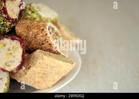 De nombreux rouleaux de délices turcs avec différentes saveurs et garnitures dans une assiette blanche sur la table. Coupes de bonbons Turk Lokumu Banque D'Images