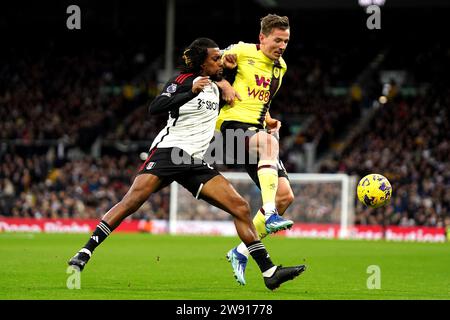 Alex Iwobi de Fulham (à gauche) et Sander Berge de Burnley se battent pour le ballon lors du match de Premier League à Craven Cottage, Londres. Date de la photo : Samedi 23 décembre 2023. Banque D'Images