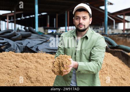 Les jeunes agriculteurs qui vérifient la qualité des brasseurs ont dépensé des grains en entreposage ouvert Banque D'Images