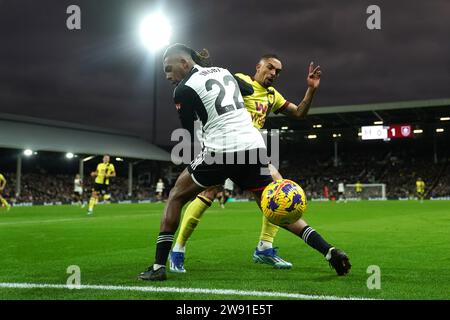 Alex Iwobi de Fulham (à gauche) et Vitinho de Burnley se battent pour le ballon lors du match de Premier League à Craven Cottage, Londres. Date de la photo : Samedi 23 décembre 2023. Banque D'Images