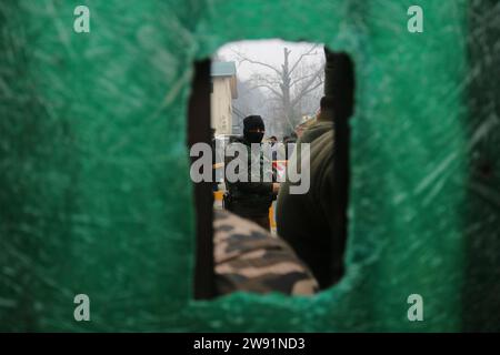 Srinagar Cachemire, Inde. 23 décembre 2023. Des policiers indiens montent la garde alors que les dirigeants et les travailleurs du Jammu-et-Cachemire Apni Party prennent part à une manifestation à Srinagar. Les partis politiques de la vallée du Cachemire manifestent contre la mort présumée de trois civils dans le district frontalier de Poonch au Jammu-et-Cachemire. Les trois personnes ont été retrouvées mortes dans des circonstances mystérieuses le 22 décembre au soir, au même endroit où quatre soldats ont été tués et trois autres blessés dans une attaque militante le 21 décembre après-midi, ont indiqué des responsables et des résidents. Le 23 décembre 2023, Srinagar Cachemire, Inde. (Photo B Banque D'Images