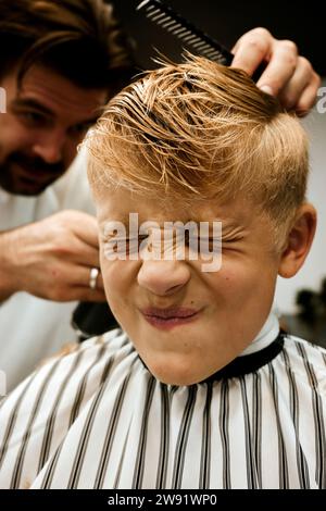 Client se faisant couper les cheveux par un barbier Banque D'Images