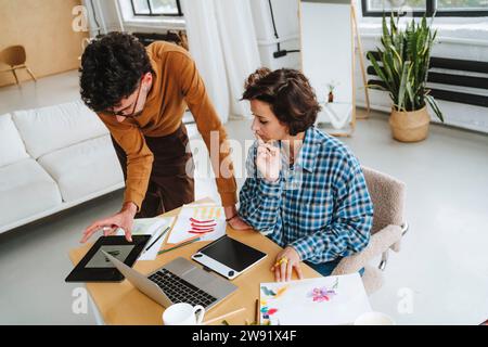 Jeunes illustrateurs de design planifiant ensemble au bureau Banque D'Images