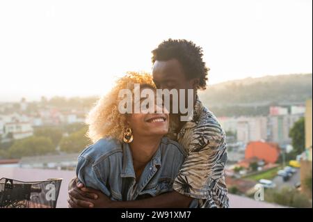 Homme romantique embrassant la femme transgenre au coucher du soleil Banque D'Images