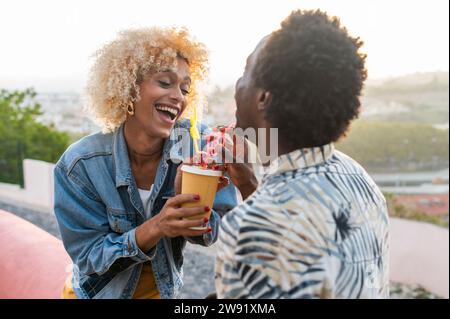 Heureuse femme transgenre ayant du jus avec son petit ami Banque D'Images