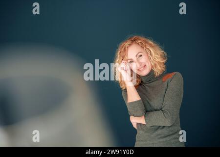Femme souriante debout devant le mur Banque D'Images