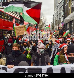 Londres, Royaume-Uni. 23 décembre 2023. Les manifestants brandissent des drapeaux palestiniens pendant la manifestation à Oxford Street. Les manifestants pro-palestiniens ont défilé dans le quartier commerçant de Londres avant Noël, appelant à un cessez-le-feu. Crédit : SOPA Images Limited/Alamy Live News Banque D'Images