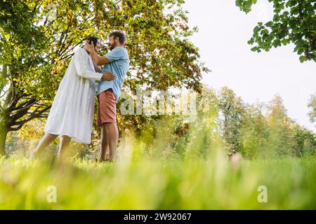 Couple romantique debout sur l'herbe au parc Banque D'Images