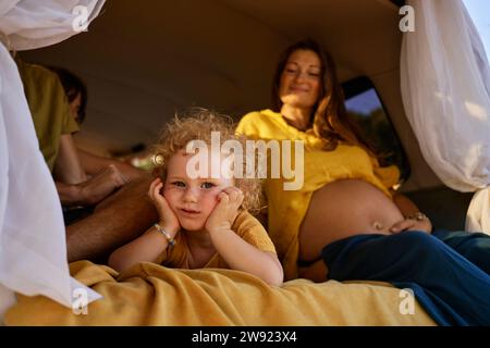 Jolie fille couchée par la mère enceinte dans la caravane Banque D'Images