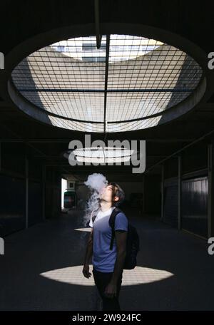 Homme fumant sur le sentier souterrain Banque D'Images