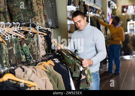 Homme choisissant des vêtements de camouflage Banque D'Images